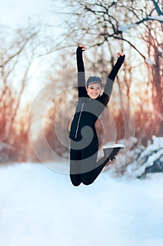Happy Girl in Sportswear Outfit Jumping in the Snow