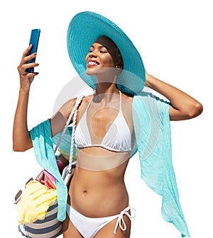 Happy girl in summer beach holiday wearing bikini, blue sun hat and pareo holding beach bag and using mobile phone isolated in