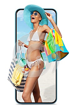 Happy girl in summer beach holiday wearing bikini and sun hat with beach bag and towel, comes out of screen phone isolated in