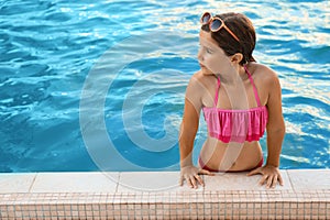 Happy girl with sunglasses in swimming pool