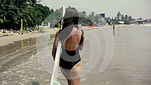 Happy girl surfer running laughing cheerful having fun with surfing boogieboard on summer holidays