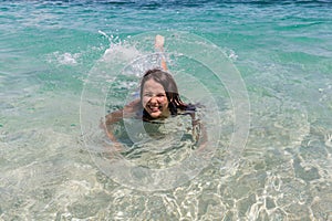 Happy girl swimming in the blue sea