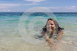 Happy girl swimming in the blue sea