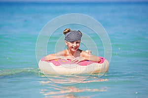 Happy girl swimming in a circle on the sea.