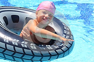 Happy girl swimming at the inflatable circle