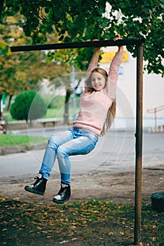 Happy girl swinging on the crossbar