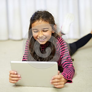 Happy, girl and tablet on floor in apartment for streaming, gaming and watch movie online. Smile, child and technology
