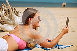 Happy girl taking selfie photo on beach.