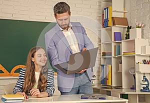 happy girl with teacher in classroom use laptop