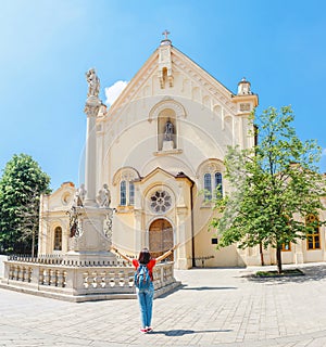 Happy girl tourist traveler enjoys a marvelous view of the architecture of the old Capuchin church in Brastilava,