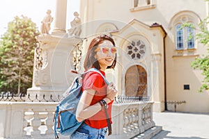 Happy girl tourist traveler enjoys a marvelous view of the architecture of the old Capuchin church in Brastilava,