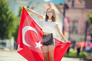 Happy girl tourist walking in the street with turkey flag photo