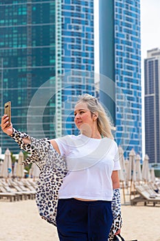 Happy girl traveler taking selfie photo for her social networks in modern Finance center and bay area. Student and