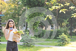 Happy girl using a smart phone voice recognition audio ai message speech function on line walking on a park background