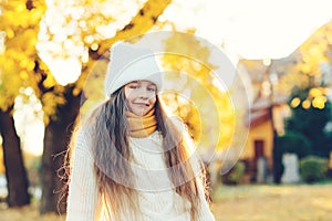 Happy girl walking in autumn park. Little girl wearing warm knitted sweater