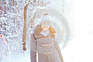 Happy girl walking in a beautiful winter forest