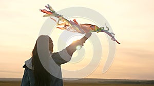 A happy girl is walking with a colorful kite in the sun. The child dreams of freedom, flight and travel. The teenager