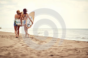 Happy girl walking with surf board on the sandy beach