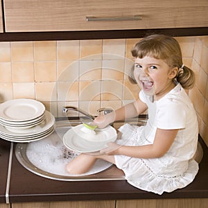 Happy girl washing dishes