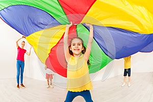 Happy girl waving parachute during sports festival