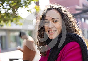 Happy girl with wavy hair laughing outdoor with urban city context as background - Millennial or gen z woman having fun outdoor