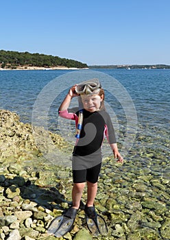 Happy girl with wetsuit, masks and snorkels at the s photo