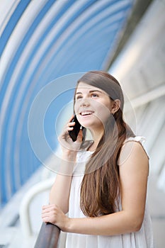 Happy girl in white blouse stands in light gallery