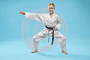 Happy girl in white kimono standing in universal stance