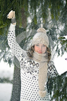 Happy girl in the winter forest play with fir-tree