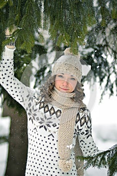 Happy girl in the winter forest play with fir-tree