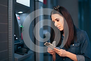 Woman Courting Money in Front of ATM Machine photo