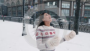 Happy girl in woolen sweater enjoying winter snowy morning.