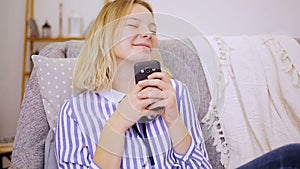 Happy girl writes messages on smartphone