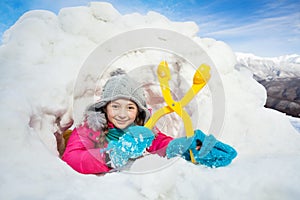 Happy girl with yellow snowmaker in the snow igloo