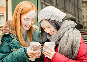 Happy girlfriends best friend having fun with coffee and phones photo