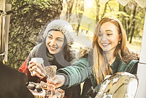 Happy girlfriends best friends sharing time together outdoors with coffee