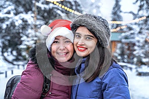 Happy girlfriends at christmas time outdoors. Smiling positive friends on winter background. Portrait of two women