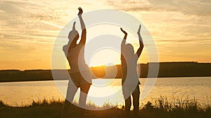 Happy girls dancing on the beach. party by the lake, children dancing. beautiful girls having fun listening to music