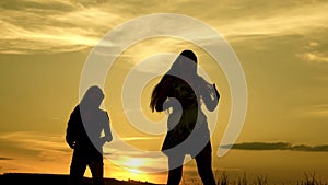 Happy girls dancing on the beach. Party by the lake, children dancing. Beautiful girls having fun listening to music