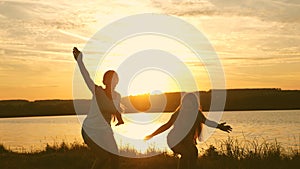 Happy girls dancing on the beach. party by the lake, children dancing. beautiful girls having fun listening to music