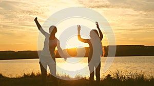 Happy girls dancing on the beach. party by the lake, children dancing. beautiful girls having fun listening to music