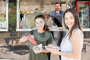 Happy girls eating at a food truck