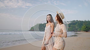 Happy girls going to the tropical, sandy beach on paradise island, amazing sea surf. Young pretty women walking, talking