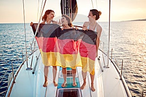 Happy girls have party on the yacht at vacation - Germany flag