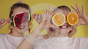 Happy girls having party and dancing on yellow background