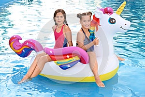 Happy girls on inflatable  in swimming pool