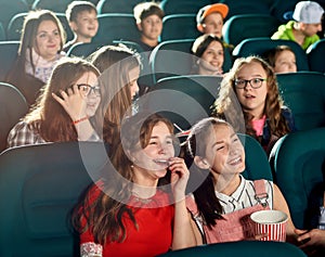 Happy girls laughing by watching movie in the cinema.