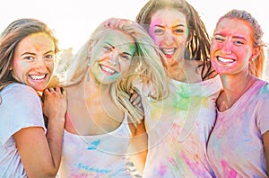 Happy girls making party at holi colors festival in summer time - Young women friends having fun on the beach musi event at sunset