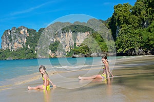 Happy girls play in sea on tropical beach