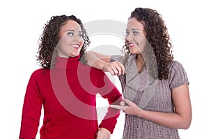 Happy girls: Portrait of real female twins wearing winter pullover.